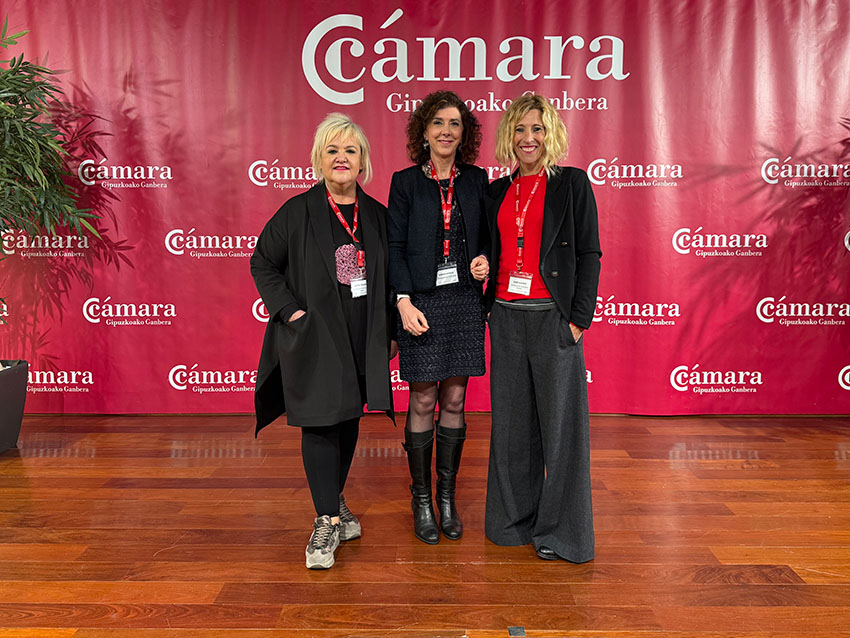 Tres mujeres, delante de un logo de la Cámara de Comercio de Gipuzkoa