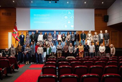 Un amplio grupo de personas posando en dos filas en un escenario