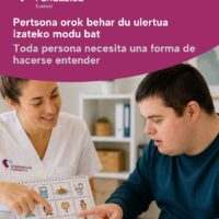 Profesional utilizando pictogramas como herramienta de comunicación con una persona con TEA y discapacidad intelectual.